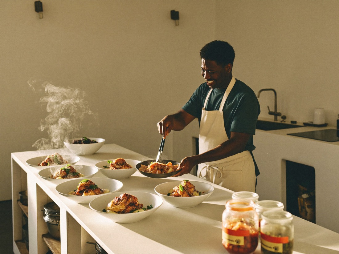 A home caterer plating soul-food dishes in his kitchen